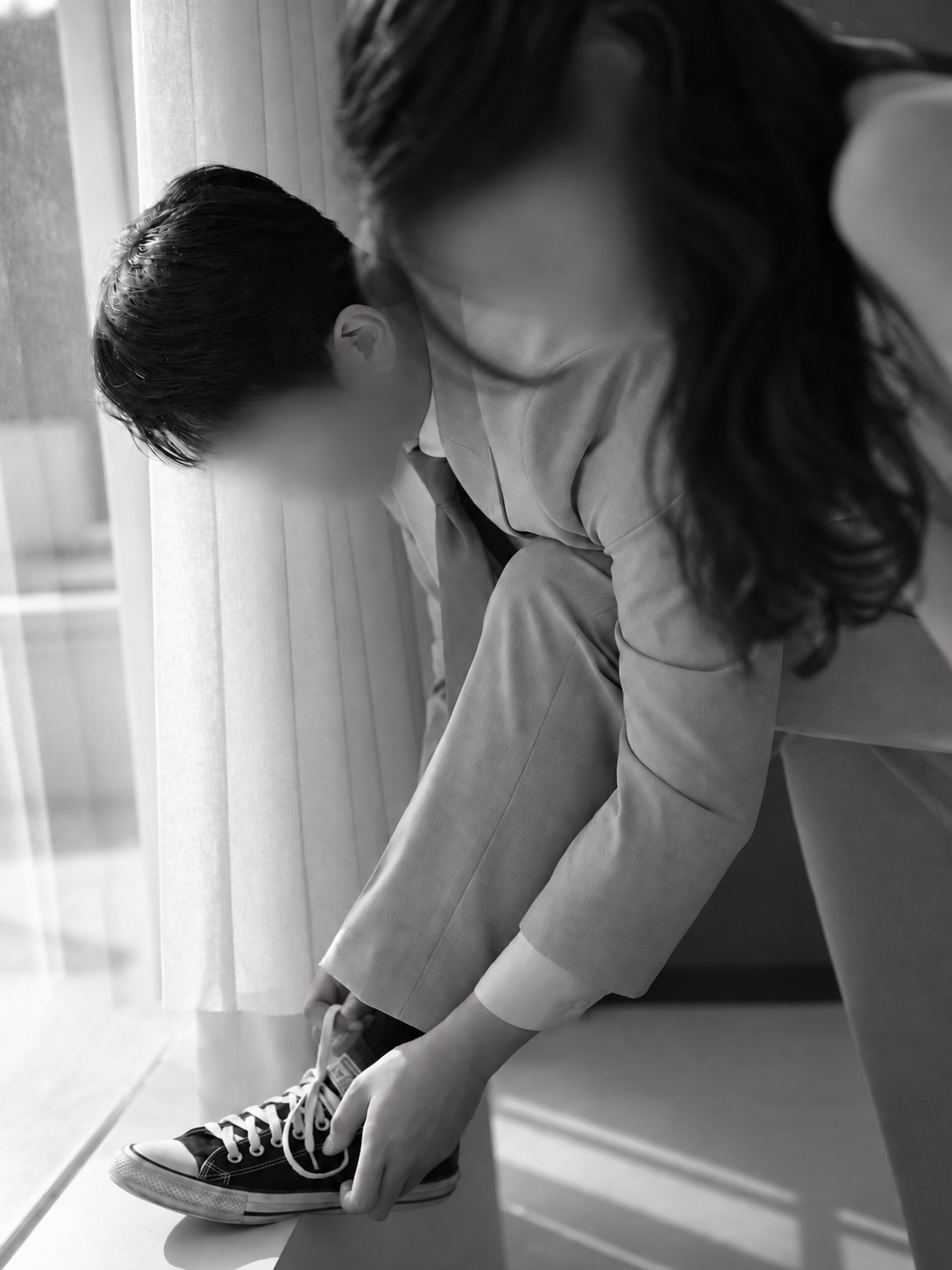 운동화 끈을 묶는 두 사람의 흑백 웨딩 사진